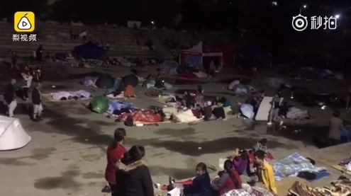 九寨沟强震居民不敢回家，把棉被、帐篷搬到户外广场打地铺度过第一夜。（图／翻摄自梨视频）