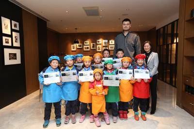 姚明与打工子弟小学文华学校的孩子们及酒店总经理张欣女士合影